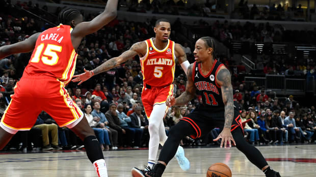 Bulls forward DeMar DeRozan dribbles the ball against Hawks guard Dejounte Murray and center Clint Capela.